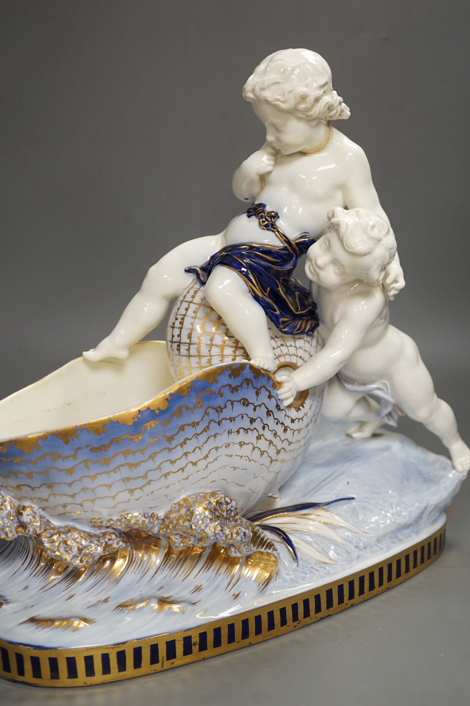 A Copeland porcelain putti seated on a shell centrepiece, modelled by O. Hale, c.1877, 35cms high